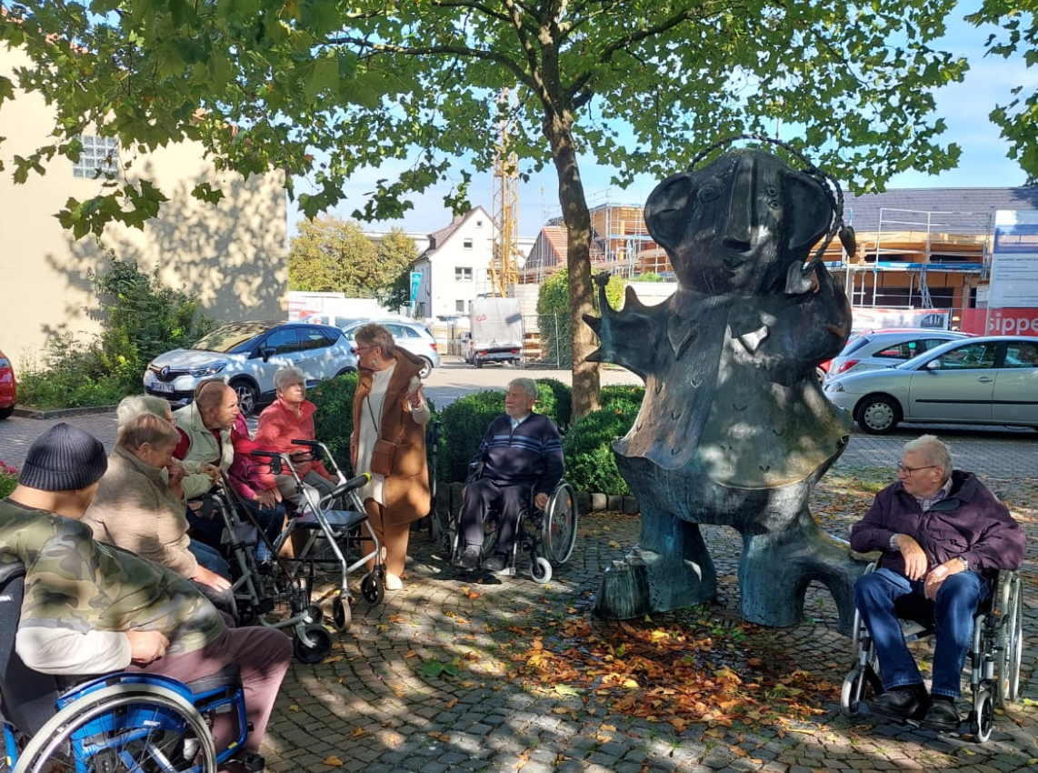 Die Besucher der Tagespflege an der großen Frau